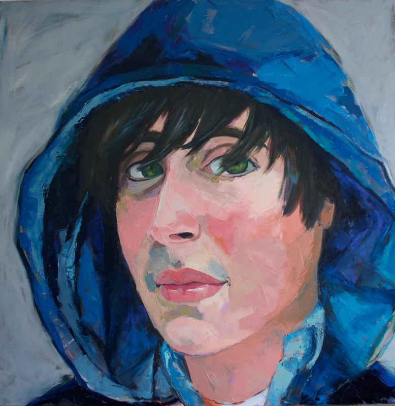Portrait of a white man with blue eyes and wearing a blue hoodie.
