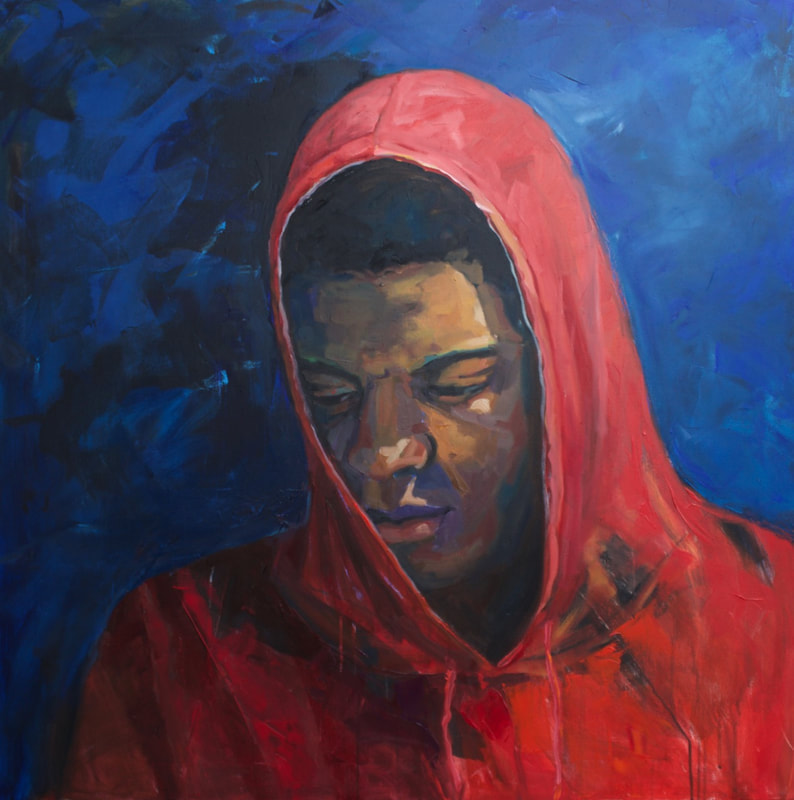 Portrait of black teenage boy in a red hoodie on a blue background