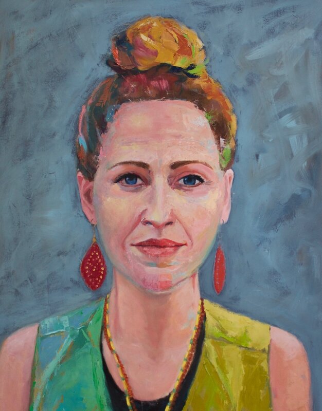 Portrait of a woman with an updo and red earrings.