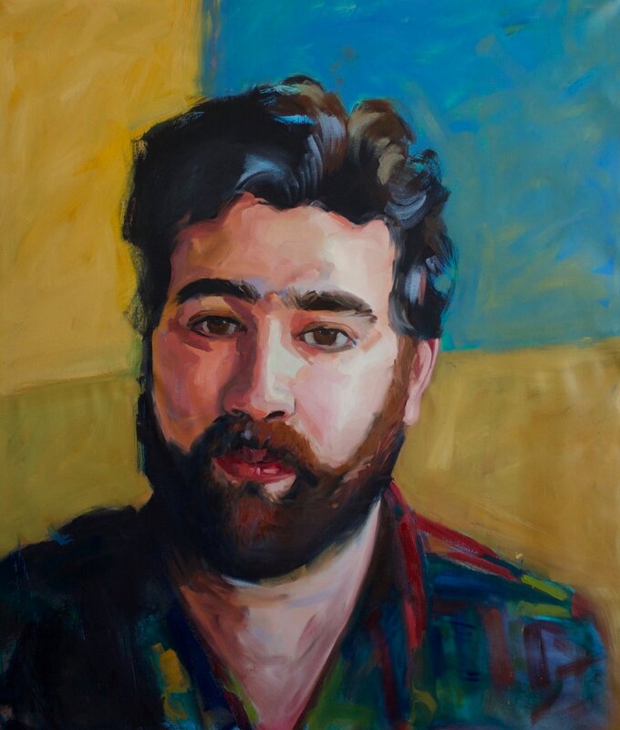 Portrait of a man with a black beard and a plaid shirt on a gold background.