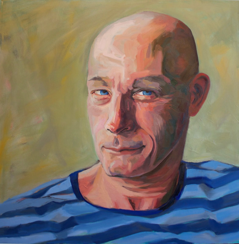 Portrait of a white bald man with a crooked smile and striped shirt.